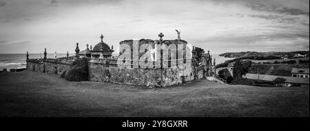 Tranquillo e storico cimitero in pietra con sculture intricate e statue di angelo che si affacciano sull'oceano, situato a Comillas, sull'oceano Atlantico Foto Stock