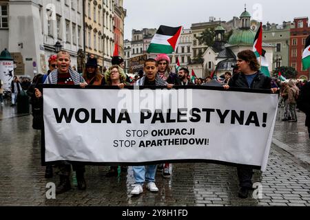 Cracovia, Polonia. 5 ottobre 2024. I manifestanti tengono uno striscione durante la manifestazione palestinesi, libanesi e i loro sostenitori hanno organizzato una protesta a sostegno della Palestina e contro le azioni di guerra israeliane nella Striscia di Gaza, in Cisgiordania e in Libano nella piazza principale della città vecchia di Cracovia. Credito: SOPA Images Limited/Alamy Live News Foto Stock