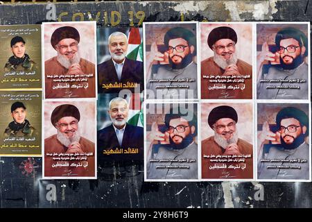 Tripoli, Libano. 5 ottobre 2024. Un poster del defunto leader filo-iraniano degli Hezbollah Hassan Nasrallah, del leader degli Hams Ismail Haniyeh e del comandante militare della brigata di al-Qassam Saeed Atallah Ali, tutti uccisi in scioperi israeliani, visti intonacati su un muro durante la processione funebre di Ali nella città portuale settentrionale libanese di Tripoli. Credito: Stringer/dpa/Alamy Live News Foto Stock