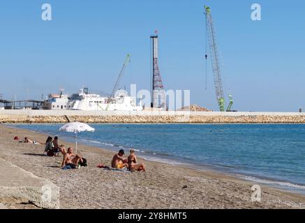 Tasucu, Turchia. 5 ottobre 2024. La spiaggia e il porto di Ta'ucu, Turchia, 5 ottobre 2024. La città sta diventando una destinazione popolare per migliaia di cittadini libanesi in fuga dal porto di Tripoli, nel nord del Libano. Molte persone stanno lasciando il Libano via nave poiché molte compagnie aeree non operano più in Libano a causa della guerra in corso. TA?ucu è il principale terminal dei traghetti della Turchia meridionale. (Foto di Elisa Gestri/Sipa USA) credito: SIPA USA/Alamy Live News Foto Stock