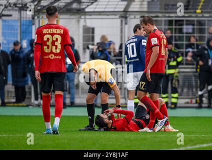 Monaco, Germania. 5 ottobre 2024. Marc Philip Eckermann (Schiedsrichter) erkundigt sich nach dem Befinden von Nikolas Agrafiotis (SV Wehen Wiesbaden, #25), der mit Schmerzen auf dem Rasen liegt. GER, TSV 1860 Muenchen gegen SV Wehen Wiesbaden, Fussball, 3. Bundesliga, 9 anni. Spieltag, Saison 2024/2025, 05.10.2024. (LE NORMATIVE DFL DFB VIETANO QUALSIASI USO DI FOTOGRAFIE COME SEQUENZE DI IMMAGINI E/O QUASI-VIDEO). Foto: Eibner-Pressefoto/Heike Feiner credito: dpa/Alamy Live News Foto Stock