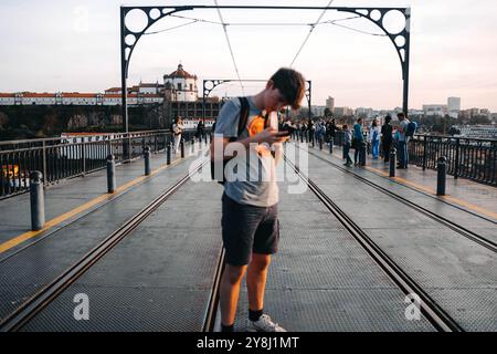 Uomo in cima a Ponte Dom Luis i a Porto, Portogallo, al telefono Foto Stock