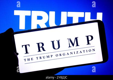 In questa immagine, il logo Trump Organization visto su uno smartphone con un logo Truth Social sullo sfondo. Foto Stock