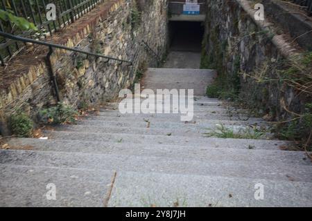 Scendendo la scalinata in pietra che conduce ad un sottopassaggio in una città italiana Foto Stock