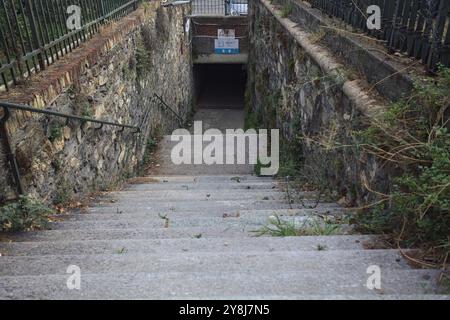 Scendendo la scalinata in pietra che conduce ad un sottopassaggio in una città italiana Foto Stock