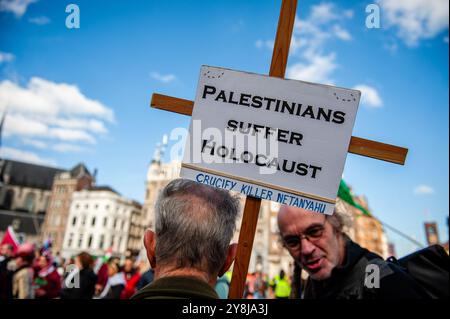 Amsterdam, Paesi Bassi. 5 ottobre 2024. Si vede un uomo che tiene in mano una croce con un messaggio a sostegno dei palestinesi durante la manifestazione. La comunità palestinese nei Paesi Bassi ha organizzato una manifestazione a sostegno della Palestina e del Libano per condannare il governo di Israele ed esprimere solidarietà ai loro cittadini. Mentre la guerra israelo-Hamas entra nel suo secondo anno, la situazione nella regione rimane tesa e imprevedibile tra gli appelli alla de-escalation da parte della comunità internazionale. Credito: SOPA Images Limited/Alamy Live News Foto Stock