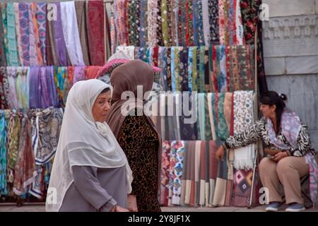 Samarcanda, Uzbekistan; 18 settembre 2024: Un gruppo di donne uzbeke, vestite con veli tradizionali, cammina per le vivaci strade di Samarcanda, Foto Stock