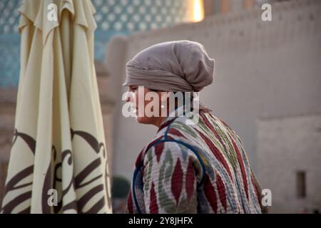 Khiva, Uzbekistan; 21 settembre 2024: Una donna uzbeka locale che prepara pane tradizionale nella storica città di Khiva, Uzbekistan. Vestito in semplice, traditi Foto Stock