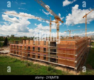 Cantiere con diverse gru sopra un bel cielo blu, senza nessuno e senza loghi Foto Stock