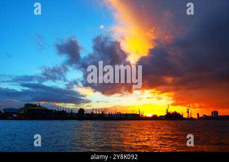 Tramonto sul molo commerciale di Amburgo. Porta la silhouette contro un cielo crepuscolo vivace Foto Stock