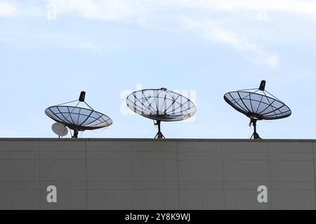 Fila di parabole satellitari in cima all'edificio. Foto Stock