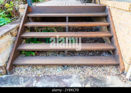 Fotografia di scale di legno su un ponte esterno che conduce a un giardino su una casa residenziale. Foto Stock