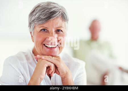 Donna anziana, ritratto e sorriso per il relax, sicuro di sé e la pensione nel fine settimana in casa con buona salute. Persona anziana, viso e felice per il comfort, Foto Stock