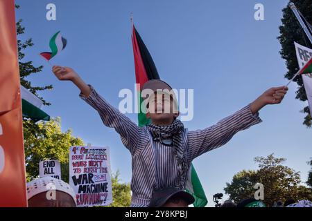 Washington DC, Stati Uniti. 5 ottobre 2024. Un ragazzo canta e mostra bandiere palestinesi durante una manifestazione pro-palestinese come parte di una giornata internazionale di azione nei pressi della Casa Bianca, Washington DC, USA, il 5 ottobre 2024. Intorno alle 16:00, circa 1.000 marciarono fuori da Lafayette Square e su H Street NW all'incrocio di Black Lives Matter Plaza e bloccarono la strada. Crediti: Aashish Kiphayet/Alamy Live News Foto Stock