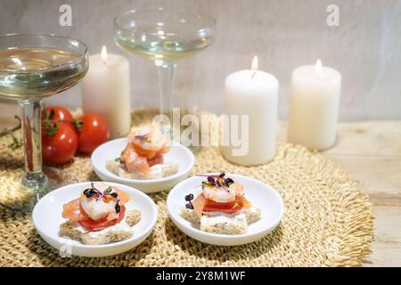 Sandwich con spuntini a forma di stella con gamberetti, salmone e pomodoro, champagne e candele, antipasto per una festa di Natale o Capodanno, co Foto Stock