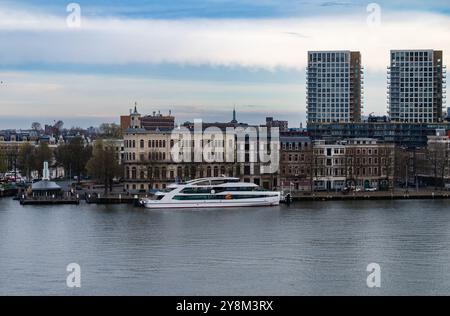 Rotterdam, Paesi Bassi - 1° aprile 2024: L'elegante barca Prinses Amalia attraccata di fronte a edifici storici e moderni lungo un fiume tranquillo, che mostra Foto Stock