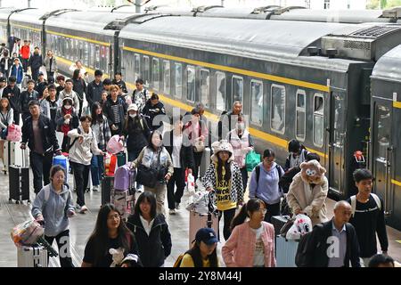 YANTAI, CINA - 6 OTTOBRE 2024 - i passeggeri scendono dal treno alla stazione di Yantai nella provincia di Shandong nella Cina orientale, 6 ottobre 2024. Foto Stock