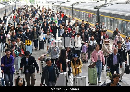 YANTAI, CINA - 6 OTTOBRE 2024 - i passeggeri scendono dal treno alla stazione di Yantai nella provincia di Shandong nella Cina orientale, 6 ottobre 2024. Foto Stock