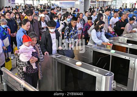 YANTAI, CINA - 6 OTTOBRE 2024 - i passeggeri entrano al cancello della stazione ferroviaria di Yantai nella provincia di Shandong nella Cina orientale, 6 ottobre 2024. Foto Stock