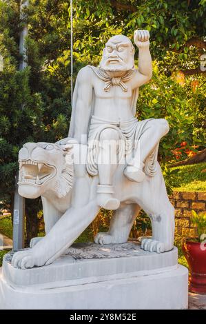 Statua buddista bianca di Buddha seduta su un leone nel parco della Pagoda Linh Ung a da Nang in Vietnam in estate in Asia Foto Stock
