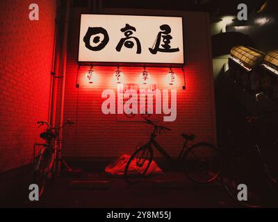 Lampade rosse con biciclette in un vicolo buio, Tokyo Foto Stock