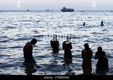 I pellegrini indù fanno un bagno sacro nel mare di fronte all'alba a Ghat Agni Theertham, Rameswaram o Rameshwaram, Pamban Island, Tamil Nadu, India, ASI Foto Stock