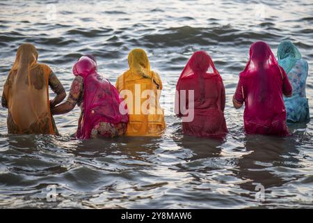 I pellegrini indù, donne in colorato saris, fanno un tuffo sacro nel mare di fronte all'alba a Ghat Agni Theertham, Rameswaram o Rameshwaram, Pamban ISL Foto Stock