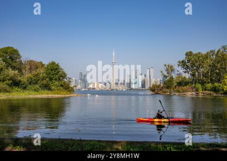Un kayak solitario sul lago Ontario, vicino a Centre Island, con lo skyline della città di Toronto come sfondo Foto Stock
