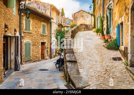 Affascinante strada nel pittoresco villaggio di Menerbes con edifici colorati e fiori vivaci. Villaggio di Menerbes (il più bel villaggio in Francia) nel Foto Stock