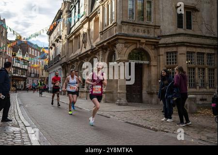 Cambridge, Regno Unito. 6 ottobre 2024. I corridori si fanno strada per le strade di Cambridge. Il Bidwells Cambridge 10k fa parte della serie Town and Gown 10k organizzata da Muscular Dystrophy 10k per raccogliere fondi per le persone che vivono con condizioni di vita muscolare. Crediti: David Tramontan / Alamy Live News Foto Stock