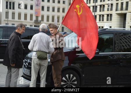 Berlino, Germania - 3 ottobre 2024 - un uomo anziano con la bandiera dell'Unione Sovietica a Pariser Platz in occasione della giornata dell'unità tedesca. (Foto di Markku Rainer Peltonen) Foto Stock