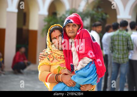 GURUGRAM, INDIA - 5 OTTOBRE: Pooja che porta in grembo la suocera di 92 anni per esprimere il loro voto per l'elezione dell'Assemblea Haryana alla scuola superiore pubblica Shiv a Sohna, il 5 ottobre 2024 a Gurugram, India. Un totale di 1.031 candidati si contestano in tutte le 90 circoscrizioni elettorali, e sono state istituite 20.632 cabine elettorali per il voto. Un totale di 2, 03, 54.350 elettori nello stato saranno in grado di esercitare i loro diritti nelle elezioni della 15a Assemblea legislativa di Haryana. (Foto di Parveen Kumar/Hindustan Times/Sipa USA ) Foto Stock