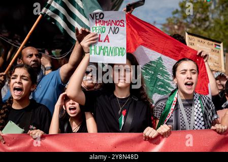 Barcellona, Spagna. 06 ottobre 2024: Una giovane donna tiene uno striscione con la scritta "vedo gli esseri umani ma non l'umanità”, mentre migliaia di persone marciano a Barcellona in solidarietà con la Palestina e il Libano per celebrare il primo anniversario della guerra tra Israele e Hamas. Immagine di credito: Jordi Boixareu/Alamy Live News Foto Stock