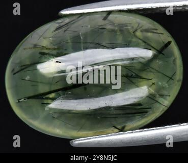 Un'affascinante pietra preziosa naturale con intriganti inclusioni verde e nero in un corpo traslucido. Foto Stock