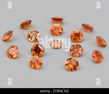 Una vivace collezione di pietre preziose di arancione naturale che mostrano scintillio radioso e tagli unici. Foto Stock