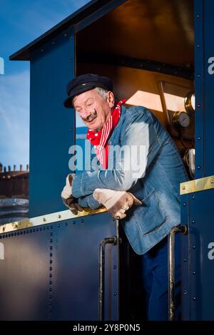 Scene di rievocazione di un lavoratore vintage o macchinista in un'autentica locomotiva 1922 con motore restaurato Foto Stock