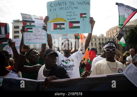 Malaga, Spagna. 6 ottobre 2024. Manifestanti che hanno bandiere e cartelli in solidarietà con la Palestina durante una manifestazione globale contro il genocidio in Palestina a seguito dell'escalation del conflitto in Medio Oriente. Un giorno prima dell'anniversario degli attentati del 7 ottobre e dell'inizio della guerra tra Israele e Hamas, migliaia di persone si recano per le strade della città di Malaga in solidarietà con il Libano e la Palestina per chiedere la fine del commercio di armi con Israele e dell'occupazione militare israeliana in Palestina. Credito: SOPA Images Limited/Alamy Live News Foto Stock