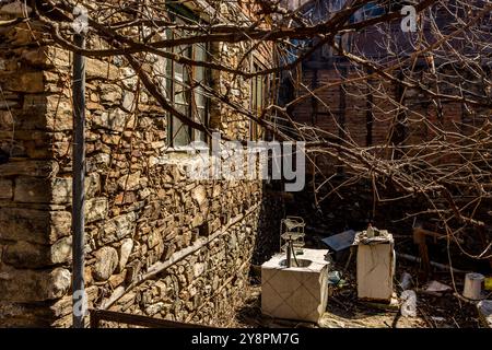 Case abbandonate e altri edifici, illuminati dalla luce del sole, vista sulla strada, villaggio di Pirin e montagna, Bulgaria Foto Stock