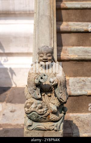 Figura di pietra del fantasma, Angelo ai piedi del tempio buddista in Asia. Statua nel tempio di Bowonniwetin. Foto Stock