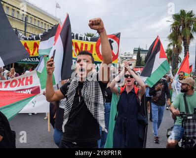 Atene, Grecia. 5 ottobre 2024. I manifestanti hanno una bandiera palestinese gigante e gridano slogan. Centinaia di manifestanti hanno marciato per le strade di Atene contro le guerre e in solidarietà con Libano e Palestina. Crediti: Dimitris Aspiotis/Alamy Foto Stock