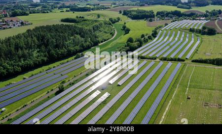 Questa splendida vista aerea cattura un vasto campo solare, che mostra una vasta gamma di pannelli solari che sfruttano l'energia del sole. La griglia ordinata si trova Foto Stock