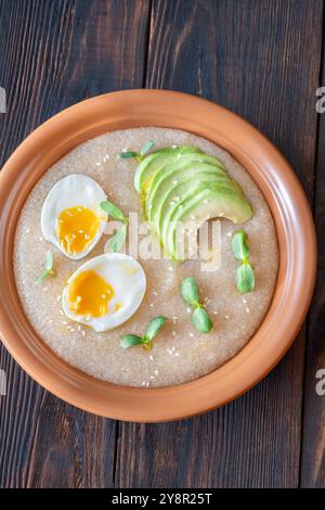 Ciotola Amaranth porridge con uova e avocado Foto Stock