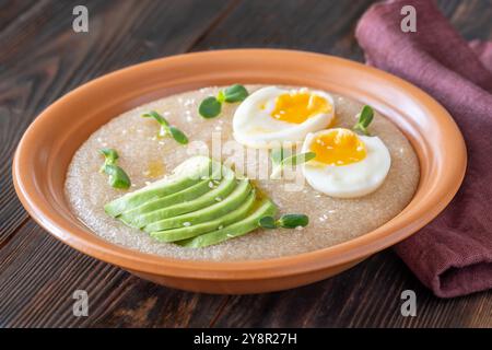 Ciotola Amaranth porridge con uova e avocado Foto Stock