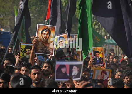 Pattan, Kashmir, India. 6 ottobre 2024. i musulmani sciiti del Kashmir portano foto del leader di Hezbollah Hassan Nasralla e gridano slogan anti Israele mentre prendono parte a una manifestazione per mostrare la loro rabbia verso l'uccisione del leader di Hezbollah Hassan Nasrallah. Nasrallah fu ucciso nei sobborghi meridionali di Beirut, in Libano, da un attacco aereo israeliano. Foto Stock