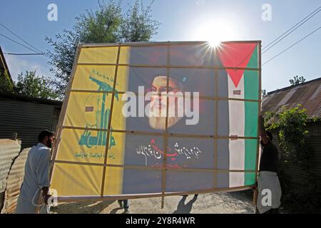 Pattan, Kashmir, India. 6 ottobre 2024. i musulmani sciiti del Kashmir portano foto del leader di Hezbollah Hassan Nasralla e gridano slogan anti Israele mentre prendono parte a una manifestazione per mostrare la loro rabbia verso l'uccisione del leader di Hezbollah Hassan Nasrallah. Nasrallah fu ucciso nei sobborghi meridionali di Beirut, in Libano, da un attacco aereo israeliano. Foto Stock