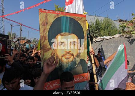 Pattan, Kashmir, India. 6 ottobre 2024. i musulmani sciiti del Kashmir portano foto del leader di Hezbollah Hassan Nasralla e gridano slogan anti Israele mentre prendono parte a una manifestazione per mostrare la loro rabbia verso l'uccisione del leader di Hezbollah Hassan Nasrallah. Nasrallah fu ucciso nei sobborghi meridionali di Beirut, in Libano, da un attacco aereo israeliano. Foto Stock