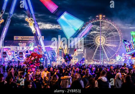 Stoccarda, Germania. 6 ottobre 2024. I visitatori accorrono alla 177a Cannstatter Volksfest illuminata sul Cannstatter Wasen in serata. Il "Wasen" è il secondo festival popolare più grande della Germania dopo l'Oktoberfest di Monaco. Crediti: Christoph Schmidt/dpa/Alamy Live News Foto Stock