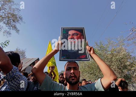 Pattan, Kashmir, India. 6 ottobre 2024. i musulmani sciiti del Kashmir portano foto del leader di Hezbollah Hassan Nasralla e gridano slogan anti Israele mentre prendono parte a una manifestazione per mostrare la loro rabbia verso l'uccisione del leader di Hezbollah Hassan Nasrallah. Nasrallah fu ucciso nei sobborghi meridionali di Beirut, in Libano, da un attacco aereo israeliano. Foto Stock