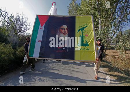 Pattan, Kashmir, India. 6 ottobre 2024. i musulmani sciiti del Kashmir portano foto del leader di Hezbollah Hassan Nasralla e gridano slogan anti Israele mentre prendono parte a una manifestazione per mostrare la loro rabbia verso l'uccisione del leader di Hezbollah Hassan Nasrallah. Nasrallah fu ucciso nei sobborghi meridionali di Beirut, in Libano, da un attacco aereo israeliano. Foto Stock