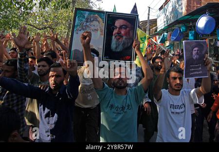 Pattan, Kashmir, India. 6 ottobre 2024. i musulmani sciiti del Kashmir portano foto del leader di Hezbollah Hassan Nasralla e gridano slogan anti Israele mentre prendono parte a una manifestazione per mostrare la loro rabbia verso l'uccisione del leader di Hezbollah Hassan Nasrallah. Nasrallah fu ucciso nei sobborghi meridionali di Beirut, in Libano, da un attacco aereo israeliano. Foto Stock